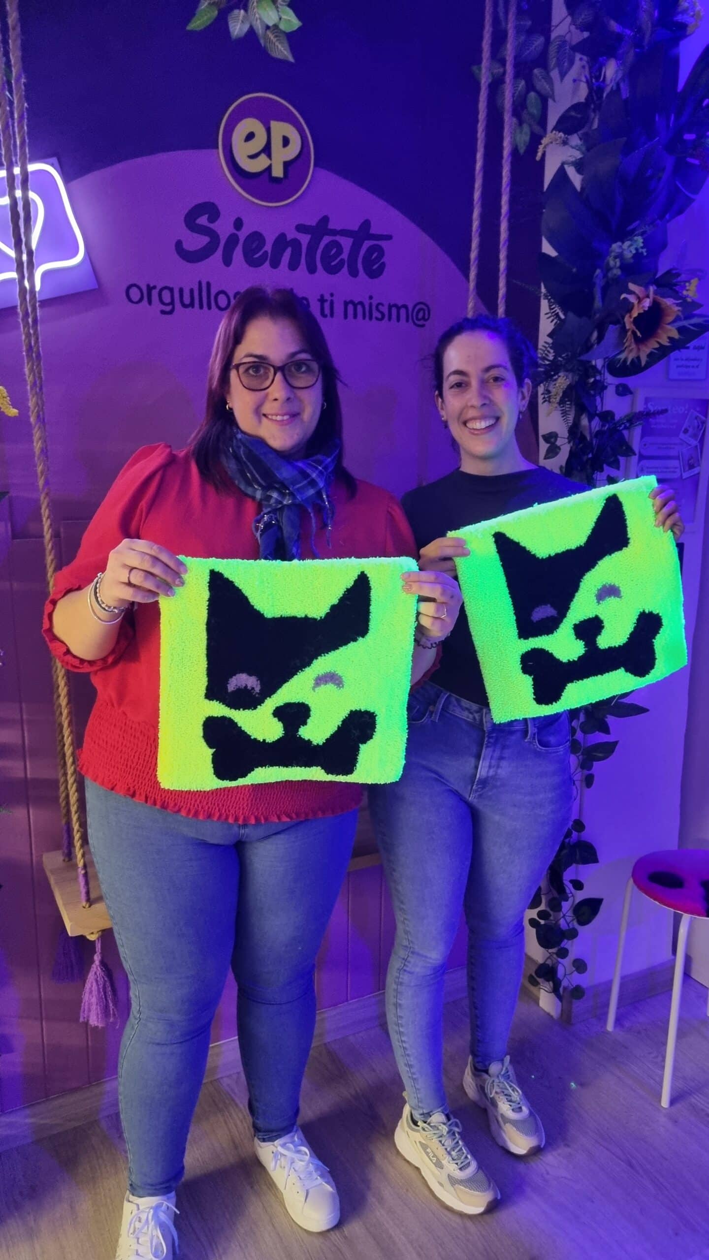 Dos clientas mostrando sus diseños en neón amarillo