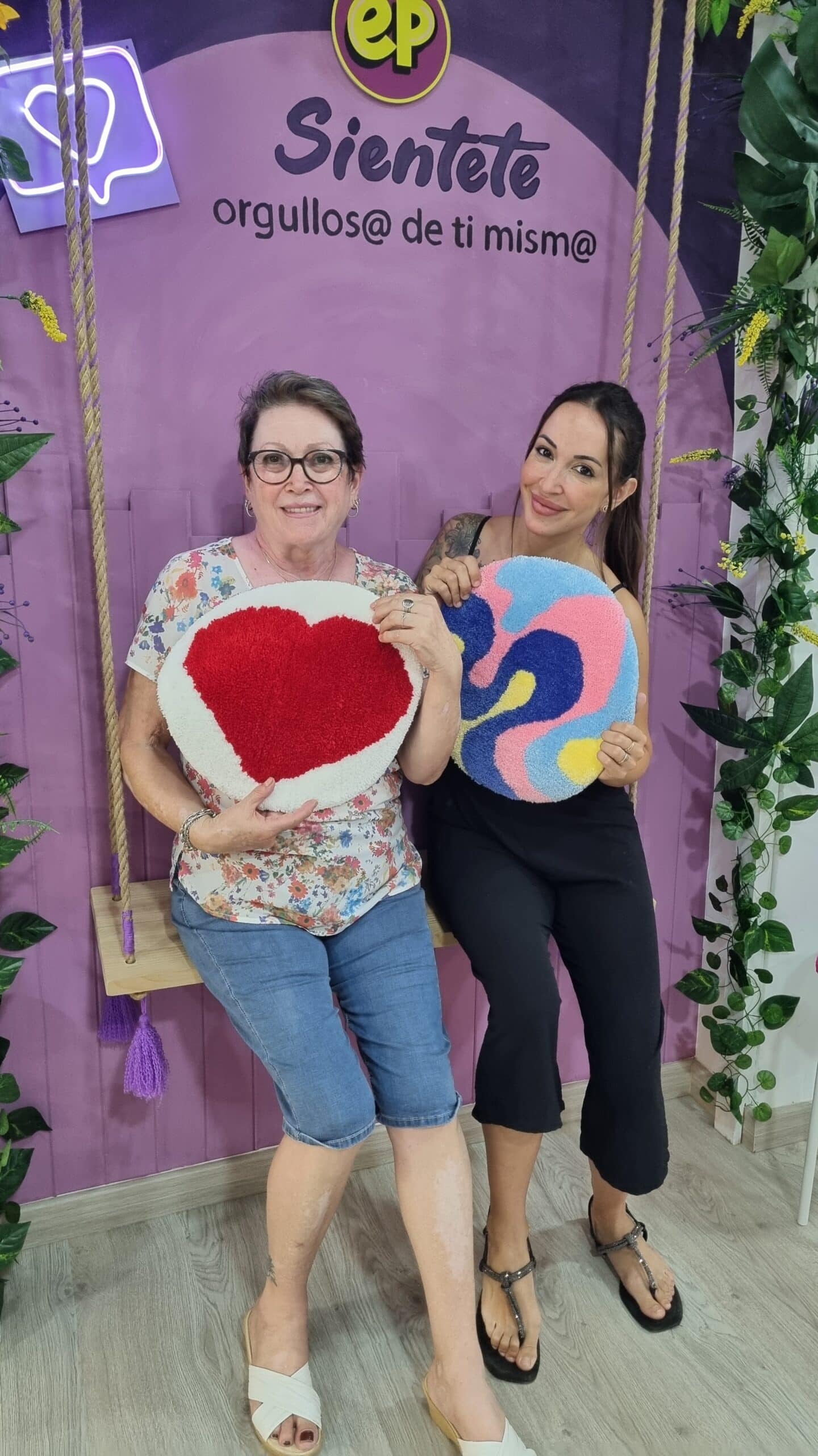 mama y su hija posando con sus creaciones de arte en alfombra