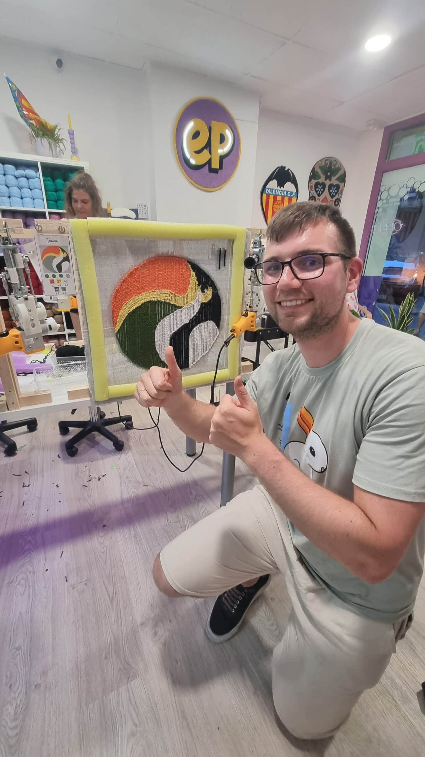 Cliente posando con su alfombra de tucán recién terminada